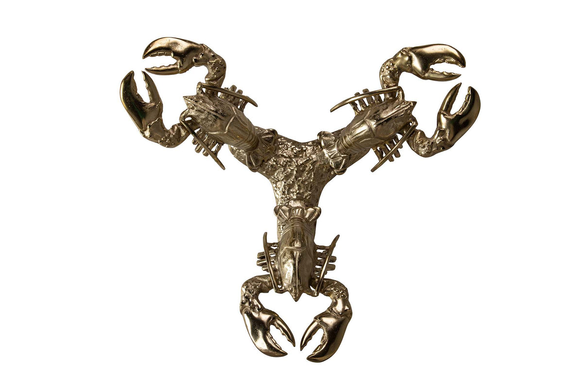 A metallic lobster-shaped wall sculpture or decorative object with a polished gold/bronze finish.