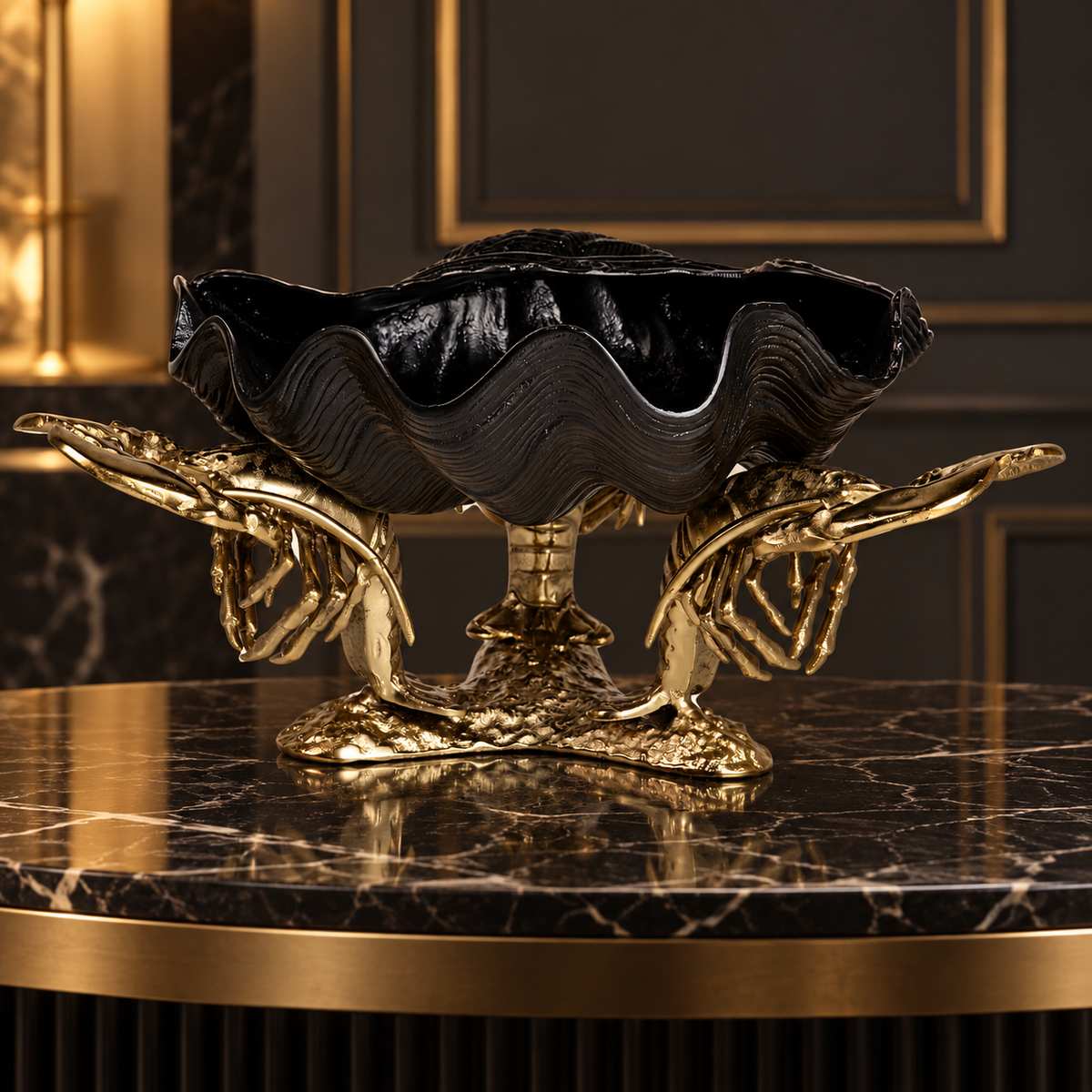 A decorative pedestal bowl with a black clam-shell style top and ornate gold claw-like supports, displayed on a dark marble table in an elegant interior setting.