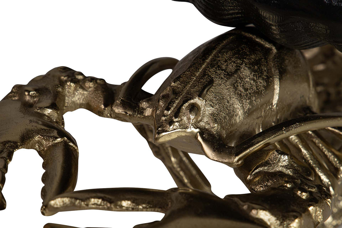 Close-up detail of a metallic lobster sculpture of champagne cooler with a textured, antique gold finish.
